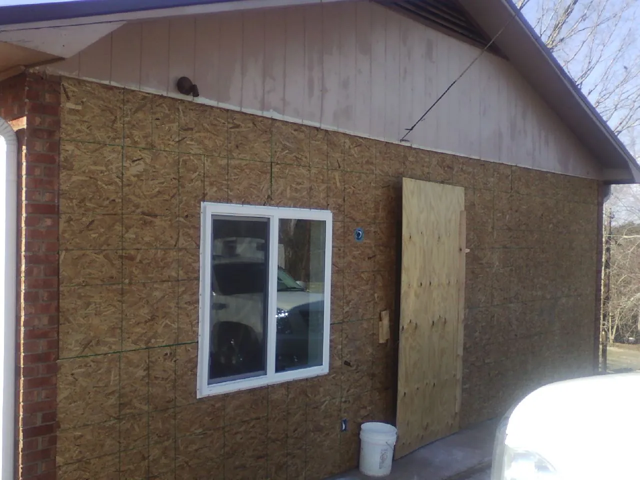 OSB sheathing on a garage addition wall before siding in Holtsville