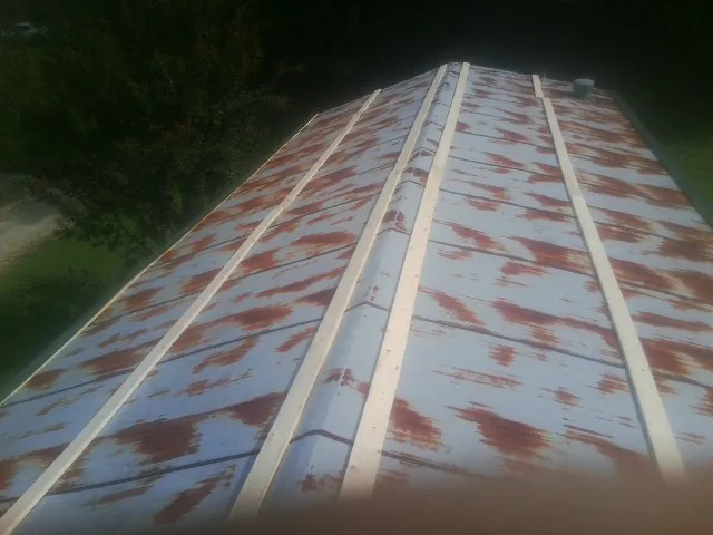 Rusted metal roof panels with new wood purlins before replacement — Storm Damage Roof Repair in Holtsville by Roofing Brothers